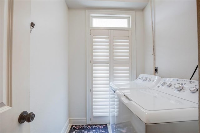 washroom featuring laundry area, baseboards, and washing machine and clothes dryer