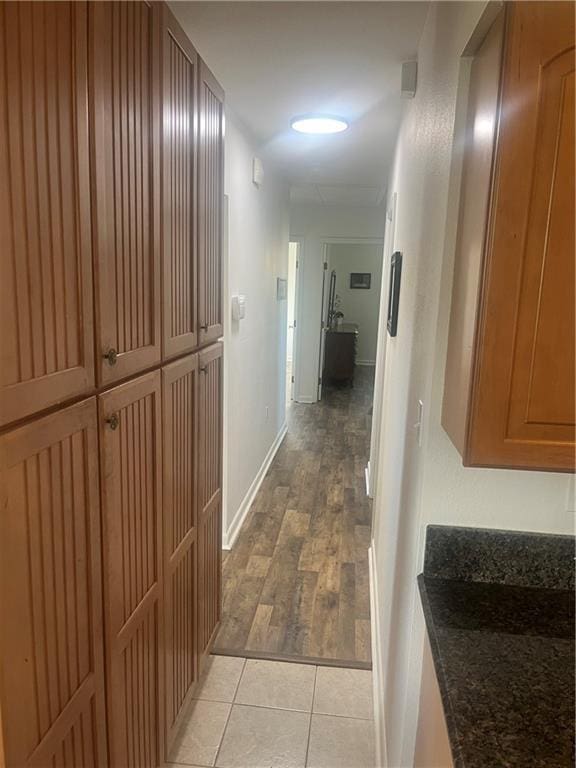 hallway with light tile patterned floors and baseboards