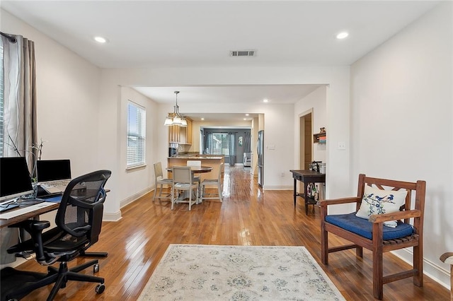 office featuring light wood finished floors, baseboards, visible vents, and recessed lighting