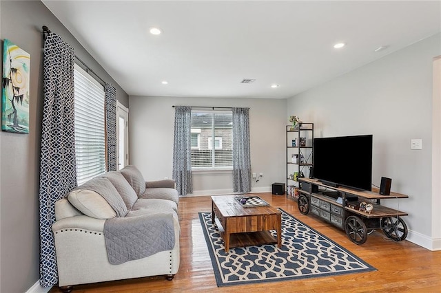 living area featuring baseboards, visible vents, wood finished floors, and recessed lighting