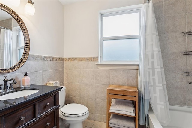 full bathroom with toilet, vanity, tile walls, and shower / bathtub combination with curtain