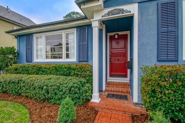 doorway to property featuring stucco siding