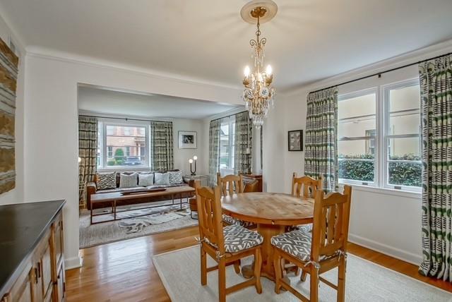 dining space featuring light wood-style floors, baseboards, and a chandelier