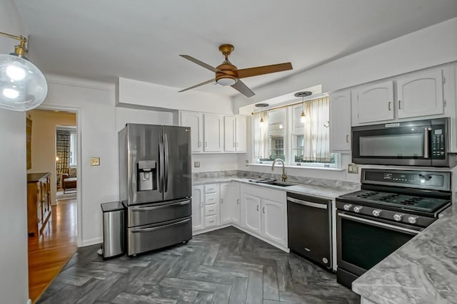 kitchen featuring stainless steel appliances, hanging light fixtures, a sink, and white cabinetry