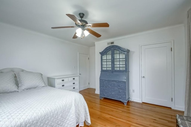 bedroom with light wood-style flooring, visible vents, and ceiling fan