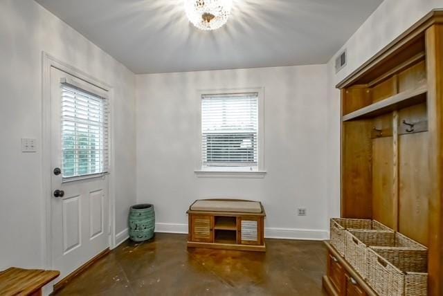 mudroom with finished concrete flooring, plenty of natural light, visible vents, and baseboards