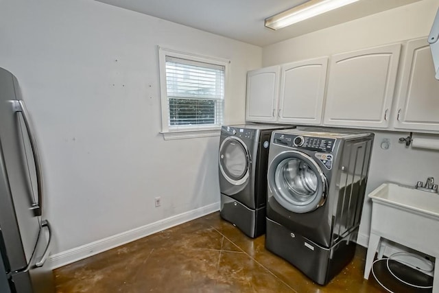 laundry area with baseboards, cabinet space, and washing machine and clothes dryer