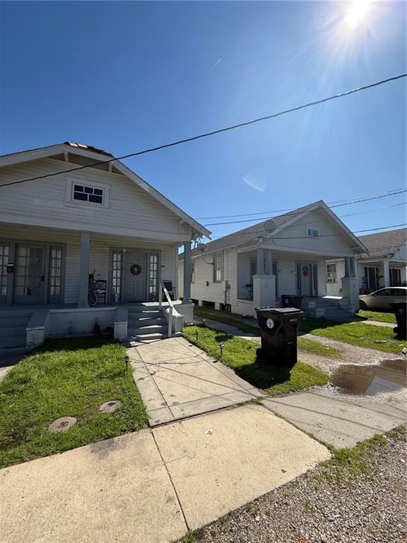 bungalow-style house with a front yard and covered porch