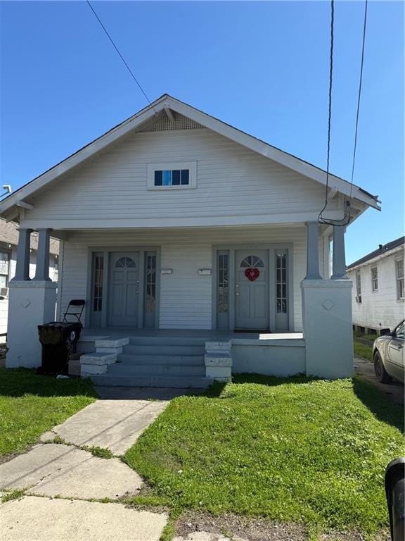 bungalow-style house featuring a front yard and covered porch