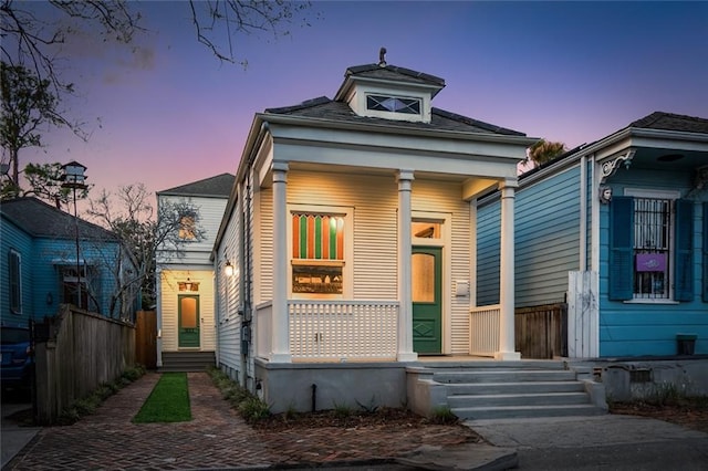 view of front of property with covered porch and fence