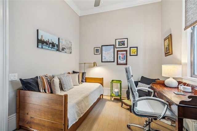 bedroom featuring baseboards, crown molding, light wood finished floors, and ceiling fan