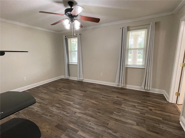 spare room featuring dark wood-style floors, crown molding, baseboards, and a ceiling fan