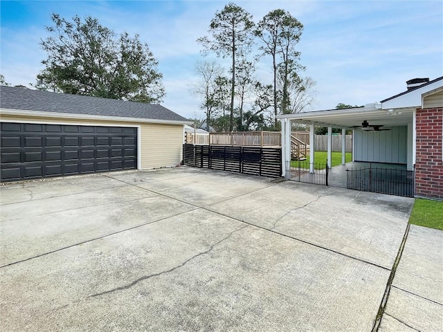 garage featuring ceiling fan, fence, and a gate