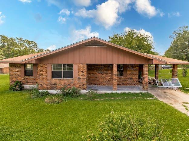 view of front of property featuring brick siding and a front yard