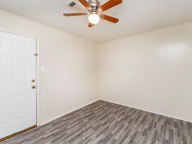 spare room featuring ceiling fan, a textured ceiling, and wood finished floors