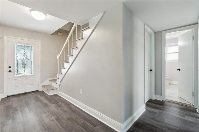 foyer featuring dark wood-style floors, baseboards, and stairway