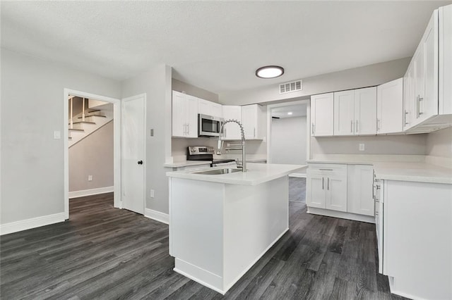 kitchen featuring stainless steel appliances, dark wood finished floors, visible vents, and a sink