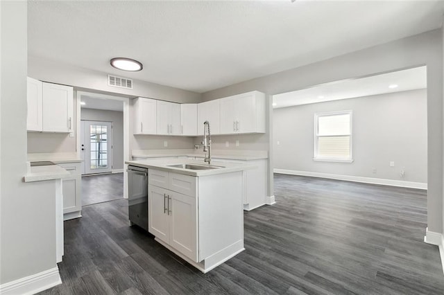 kitchen with a center island with sink, visible vents, a sink, dishwasher, and baseboards