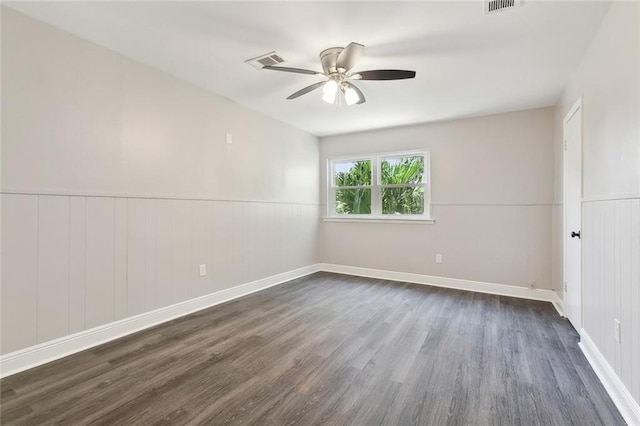 spare room with a ceiling fan, dark wood-style flooring, and visible vents