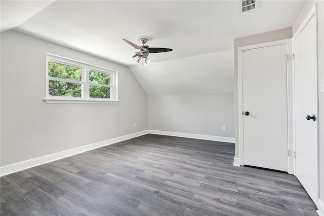 bonus room featuring lofted ceiling, baseboards, visible vents, and dark wood-type flooring