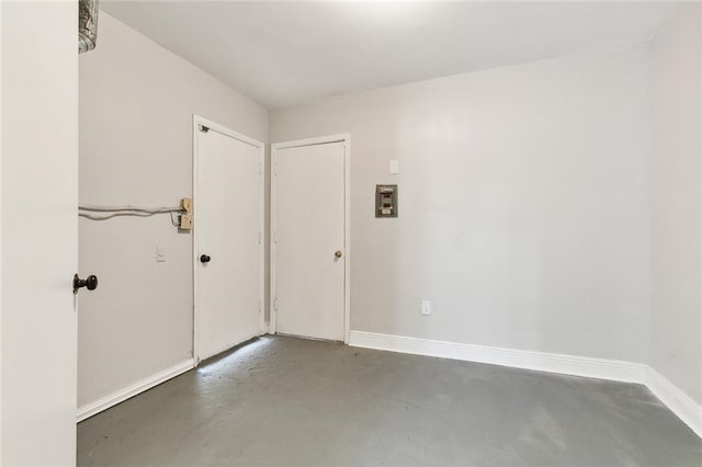 spare room with concrete floors and baseboards