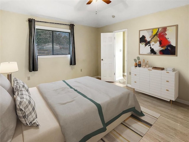 bedroom featuring light wood-type flooring, baseboards, and a ceiling fan