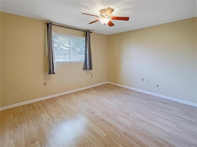 empty room featuring a textured ceiling, ceiling fan, light wood-type flooring, and baseboards