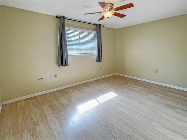 unfurnished room with a ceiling fan, light wood-style flooring, and baseboards