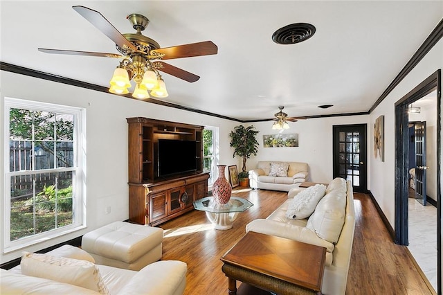 living area featuring a wealth of natural light, visible vents, and wood finished floors