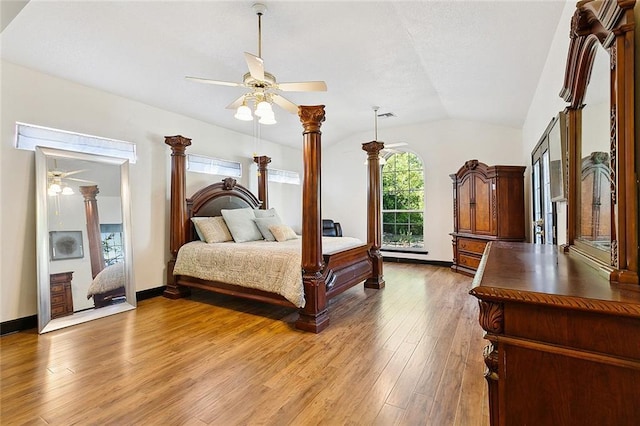 bedroom featuring decorative columns, lofted ceiling, a ceiling fan, wood finished floors, and baseboards