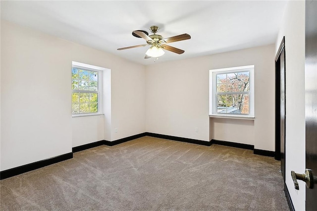 empty room featuring a ceiling fan, light carpet, and baseboards