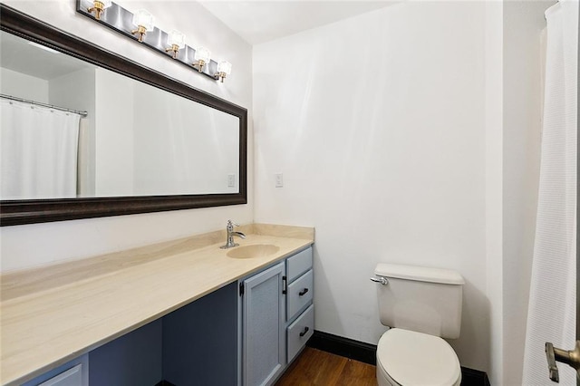 full bath featuring baseboards, vanity, toilet, and wood finished floors