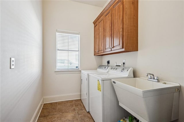 laundry area featuring cabinet space, light tile patterned floors, baseboards, separate washer and dryer, and a sink