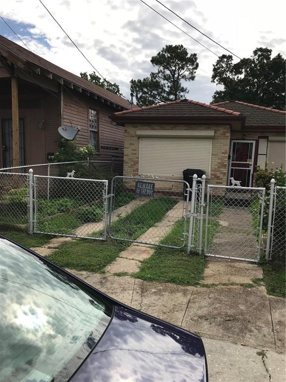 view of side of home with a fenced front yard, a gate, and a garage