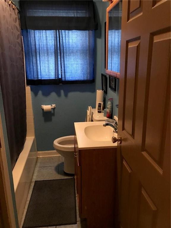 full bathroom with baseboards, toilet, tile patterned floors, shower / bath combo with shower curtain, and vanity