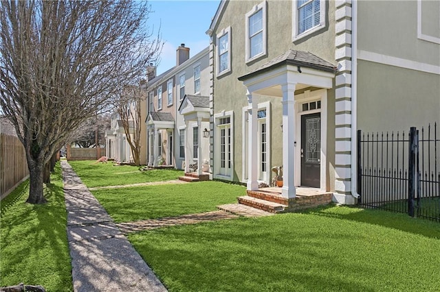 exterior space with a yard, a chimney, fence, and stucco siding