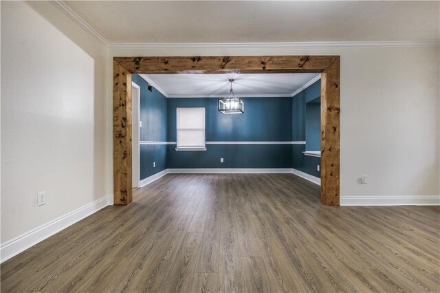 unfurnished room featuring a chandelier, baseboards, and wood finished floors