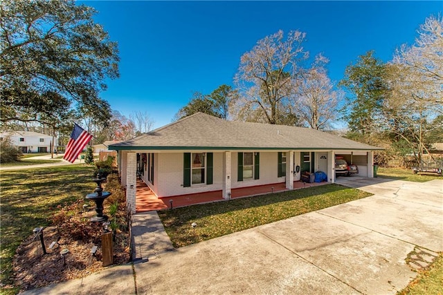 view of front facade with brick siding, a porch, concrete driveway, a carport, and a front lawn