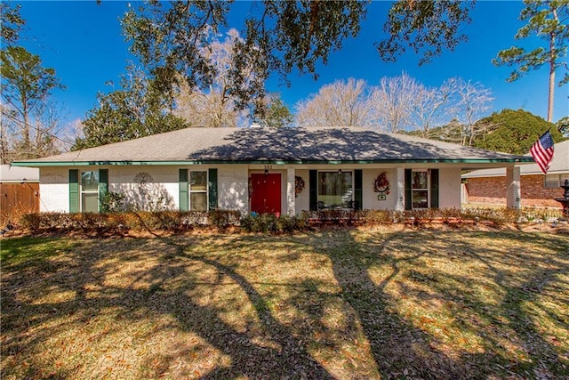 ranch-style house with a front yard, fence, and brick siding