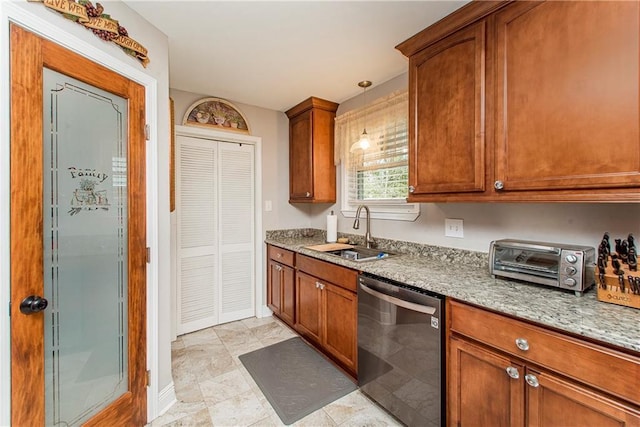 kitchen featuring light stone counters, brown cabinets, hanging light fixtures, stainless steel dishwasher, and a sink