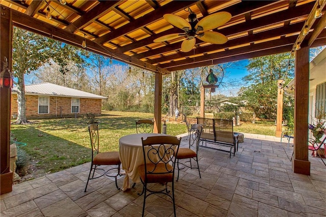 view of patio with outdoor dining area and a ceiling fan