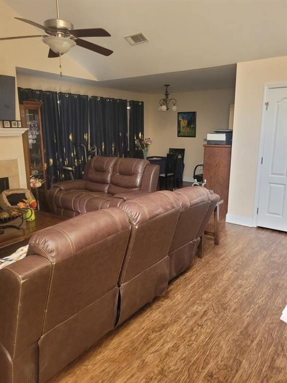 living room with baseboards, visible vents, a ceiling fan, wood finished floors, and a fireplace