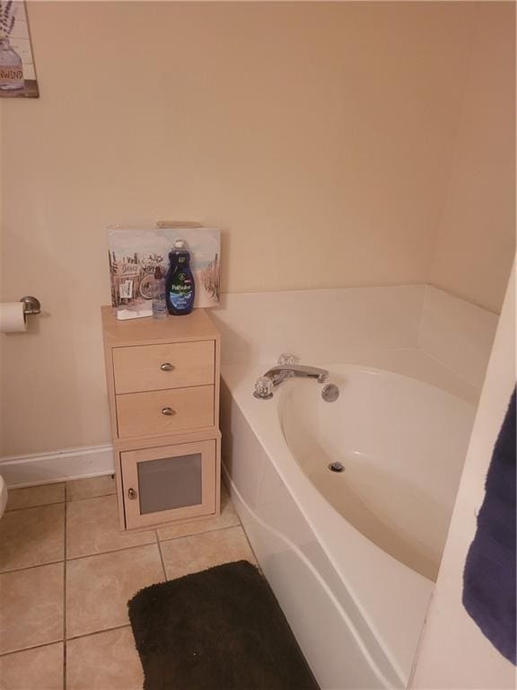 full bathroom with baseboards, toilet, a bath, and tile patterned floors