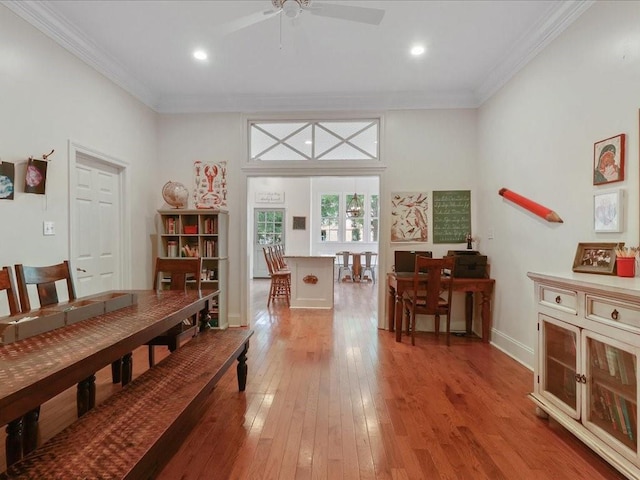 dining space with a ceiling fan, light wood-type flooring, crown molding, and baseboards