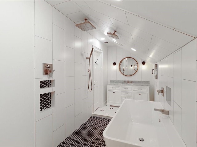 bathroom with vanity, vaulted ceiling, tiled shower, a soaking tub, and tile patterned floors