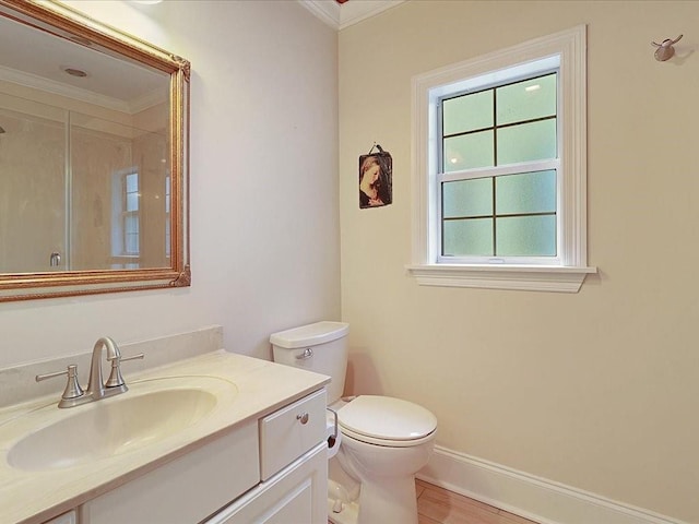 bathroom featuring toilet, wood finished floors, vanity, baseboards, and ornamental molding