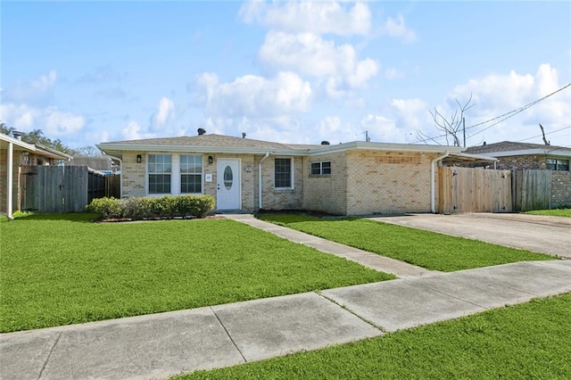 ranch-style house featuring a front yard, brick siding, fence, and driveway