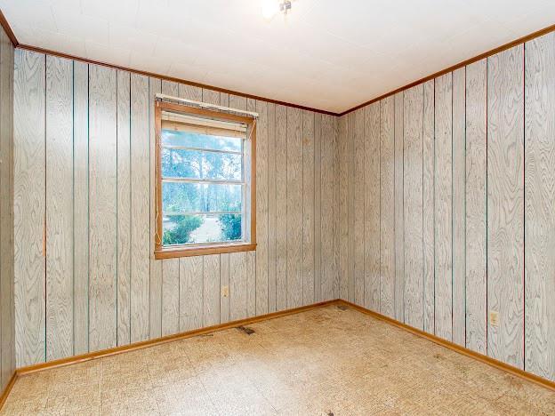 unfurnished room featuring baseboards and light floors