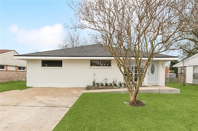 ranch-style house featuring a shingled roof, brick siding, fence, and a front lawn