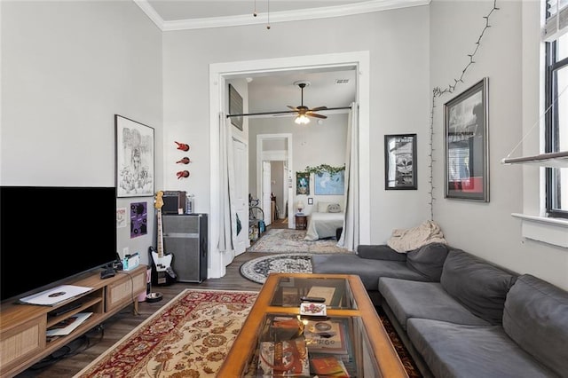 living room featuring dark wood-type flooring, crown molding, and ceiling fan